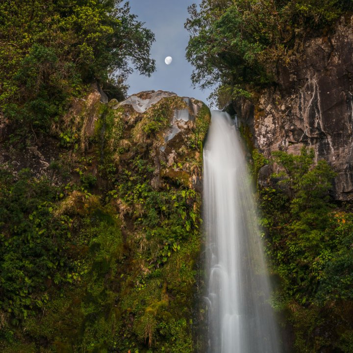 Full Moon Rising Above Waterfall in Forest